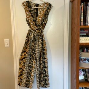 One piece jumpsuit.   Multicolor black white and gold.